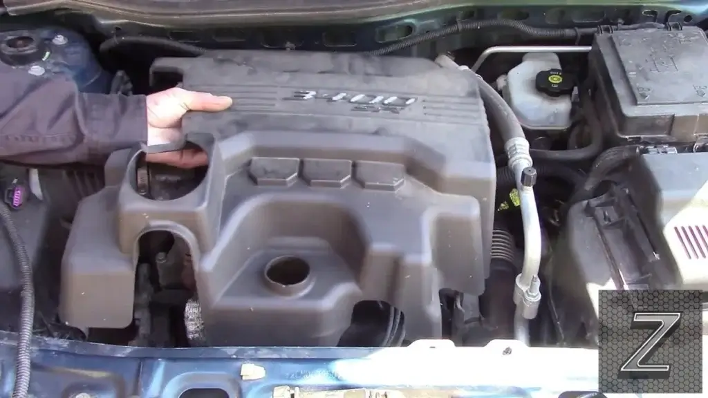 This image shows someone removing an engine vanity cover.